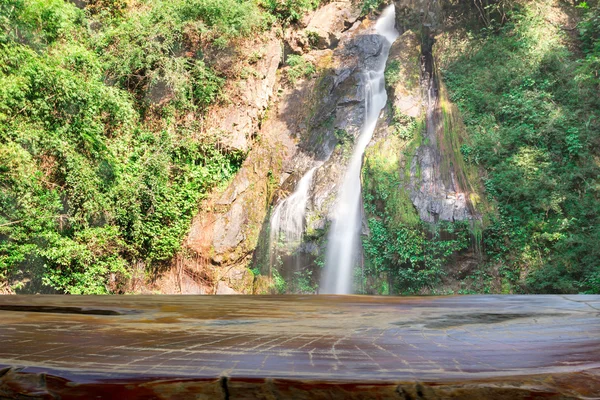 Hermosa cascada en bosque profundo y mesa de madera — Foto de Stock