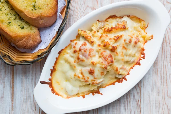 Pastas de fusilli al horno con queso cortado con pan de ajo — Foto de Stock