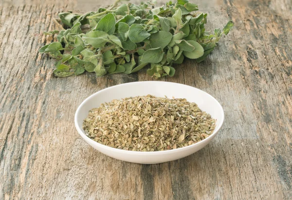 Fresh and dried oregano on wood — Stock Photo, Image