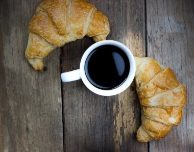 croissant and coffee, top view on old wood table