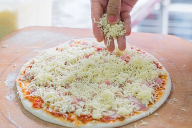 Hand of chef baker in making pizza at kitchen,