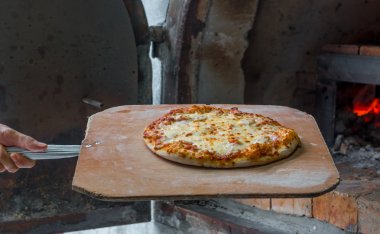 Chef Pizza take out of bread oven