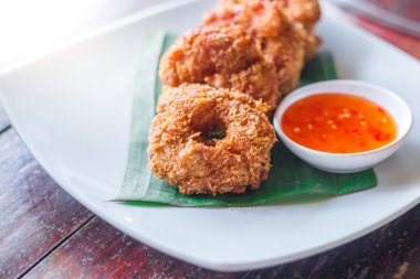 deep-fried shrimp cakes served with spicy suace on white dish