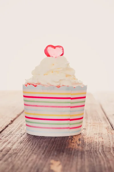 Cupcakes with icing on old wood background — Stok fotoğraf