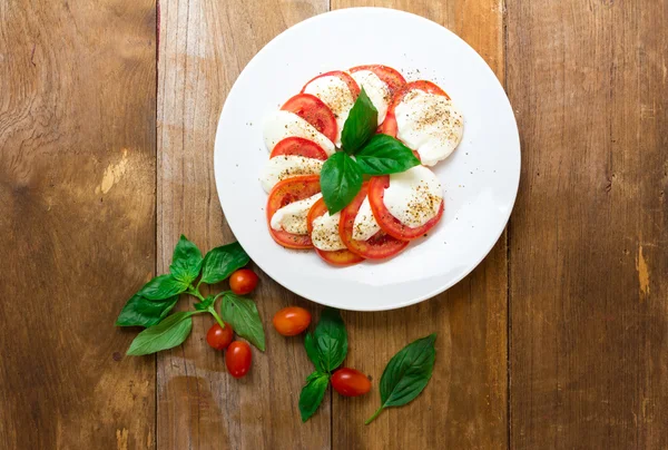 Ensalada Caprese con mozzarella, tomate, albahaca sobre plato blanco. Parte superior —  Fotos de Stock