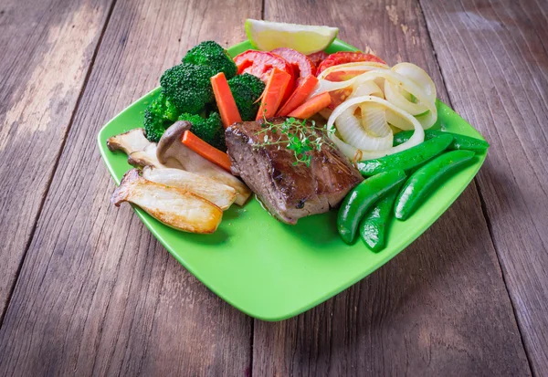 Välsmakande fisk biff med grillade grönsaker på tallriken — Stockfoto