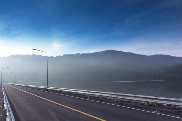 Presa y montañas bajo la niebla en la mañana — Foto de Stock