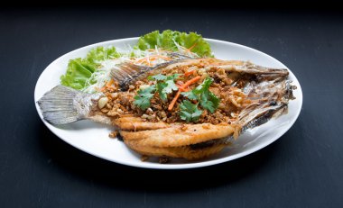 Balık yemekleri - derin yağda kızartılmış balığı balık siyah backgrou sarımsak ile