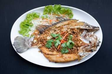 Balık yemekleri - derin yağda kızartılmış balığı balık siyah backgrou sarımsak ile