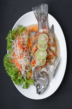 Siyah arka plan üzerine limon ile balığı buğulama balık yemek-.