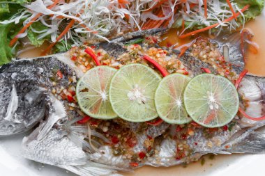 Siyah arka plan üzerine limon ile balığı buğulama balık yemek-. 