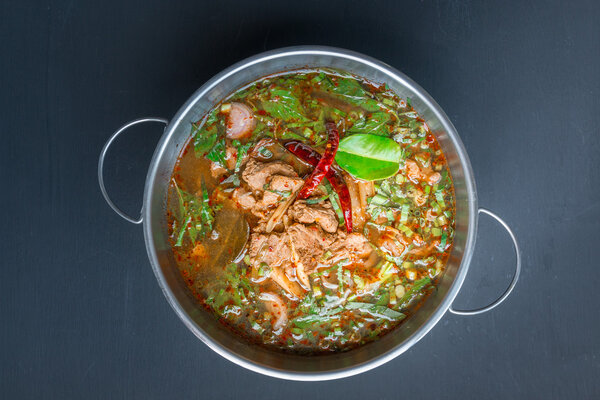 Spicy Thai style Beef soup on black background