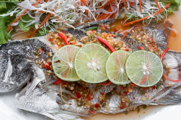 Fiskrätt - ångad snapper med citron på svart bakgrund. — Stockfoto