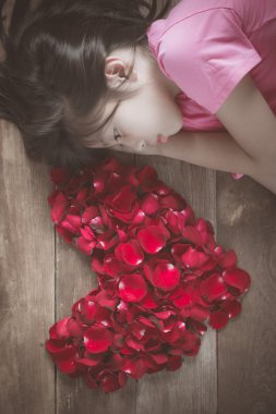 Güzel Asyalı kız kırmızı gül kalp şeklinde eski ahşap backgrou üzerinde