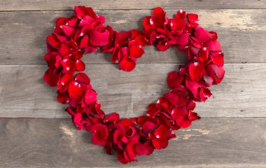 Sevgililer günü kalp yapılmış, kırmızı gül yaprakları üzerinde eski ahşap backgr
