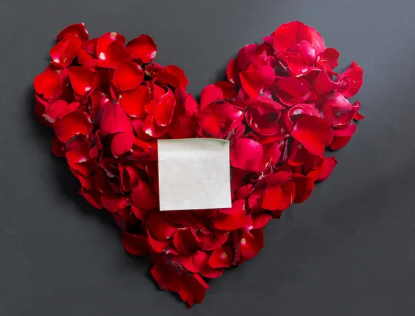 Сердце ко Дню Святого Валентина из лепестков красных роз с нотной бумагой на — стоковое фото