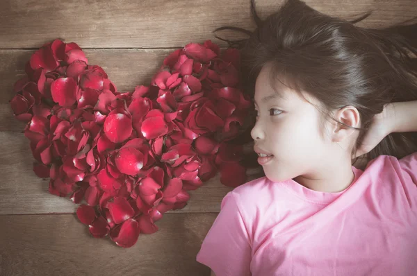 Lovely asian girl with red rose heart shape on old wood backgrou — Stock Photo, Image