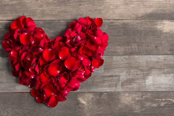 День святого Валентина сердце из красных лепестков роз на старом дереве backgr — стоковое фото