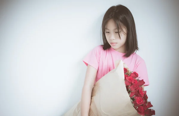 Lonely Little Asian girl with red roses bouquet, use filter imag — Stock Photo, Image