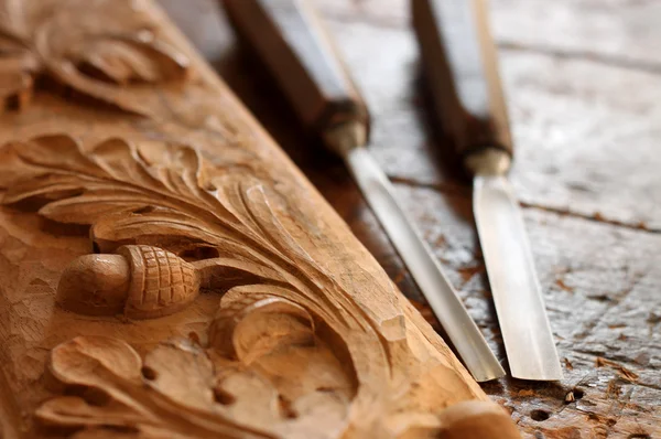 Carpenter wood chisel tool with carving on old weathered wooden workbench — Stock Photo, Image