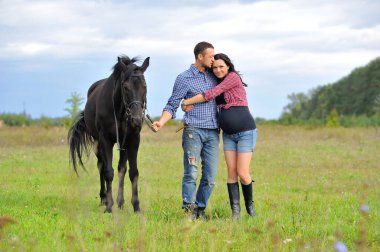 Çocuğunu bekliyor. Çayırda yürüyorum. Genç bir çift - o uzun saçlı esmer bir kadın, hamile; uzun boylu ve cesur, siyah atın dizginlerini tutan, çayırda bir yürüyüş.