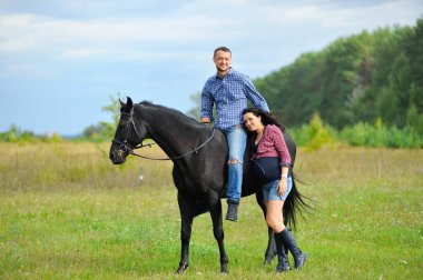 Çocuğu bekliyor, çayırda yürüyor. Genç bir çift - o uzun saçlı yakışıklı bir esmer, hamile; o uzun boylu ve cesur, siyah bir ata biniyor.