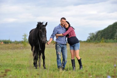 Çocuğunu bekliyor. Çayırda yürüyorum. Genç bir çift - o uzun saçlı esmer bir kadın, hamile; uzun boylu ve cesur, siyah atın dizginlerini tutan, çayırda bir yürüyüş.
