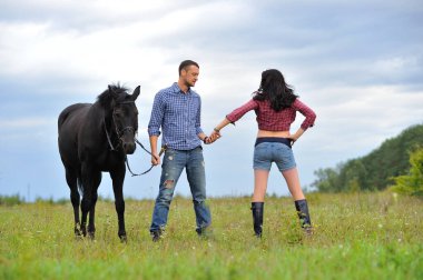 Çocuğunu bekliyor. Çayırda yürüyorum. Genç bir çift - o uzun saçlı esmer bir kadın, hamile; uzun boylu ve cesur, siyah atın dizginlerini tutan, çayırda bir yürüyüş.
