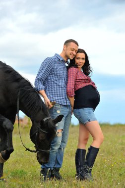 Çocuğunu bekliyor. Çayırda yürüyorum. Genç bir çift - o uzun saçlı esmer bir kadın, hamile; uzun boylu ve cesur, siyah atın dizginlerini tutan, çayırda bir yürüyüş.