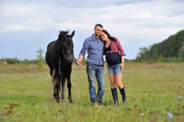 Çocuğunu bekliyor. Çayırda yürüyorum. Genç bir çift - o uzun saçlı esmer bir kadın, hamile; uzun boylu ve cesur, siyah atın dizginlerini tutan, çayırda bir yürüyüş.