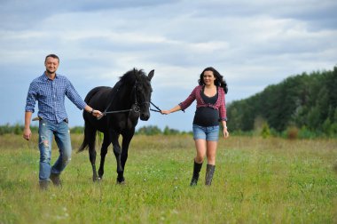 Çocuğunu bekliyor. Çayırda yürüyorum. Genç bir çift - o uzun saçlı esmer bir kadın, hamile; uzun boylu ve cesur, siyah atın dizginlerini tutan, çayırda bir yürüyüş.