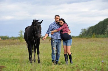 Çocuğunu bekliyor. Çayırda yürüyorum. Genç bir çift - o uzun saçlı esmer bir kadın, hamile; uzun boylu ve cesur, siyah atın dizginlerini tutan, çayırda bir yürüyüş.