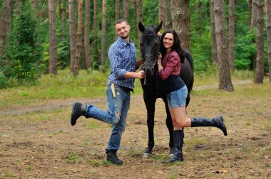 Çocuğunu bekliyor. Genç bir çift - uzun saçlı, hamile, yakışıklı bir esmer; uzun boylu ve cesur, siyah atın dizginlerini tutan, çiftlikte bir yürüyüş.