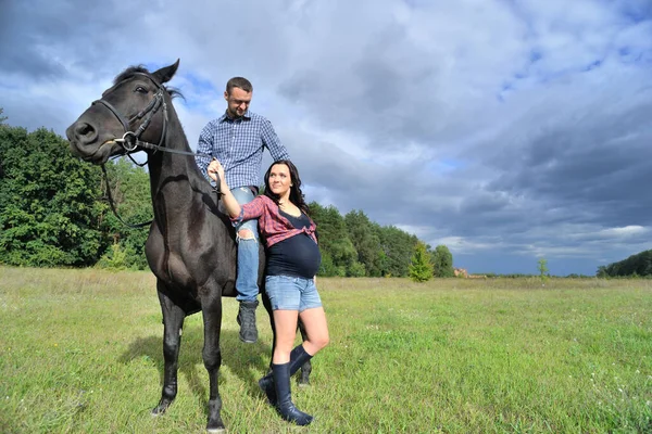 Çocuğu bekliyor, çayırda yürüyor. Genç bir çift - o uzun saçlı yakışıklı bir esmer, hamile; o uzun boylu ve cesur, siyah bir ata biniyor.