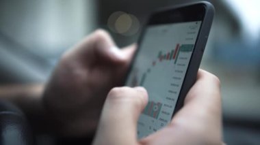 İşadamı borsa verilerini kontrol etmek için cep telefonu kullanıyor