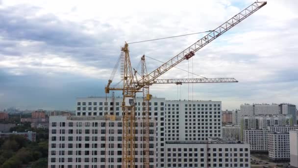 Construcción de grúas y casas de apartamentos sin terminar en construcción, drone tilt up shot — Vídeo de stock