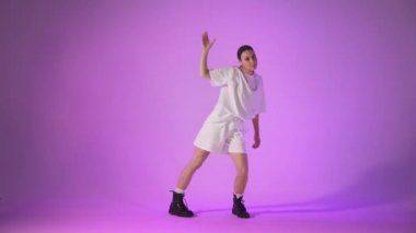 Menekşe arka planda hip hop dansı yapan genç bir kadın, stüdyo çekimi.