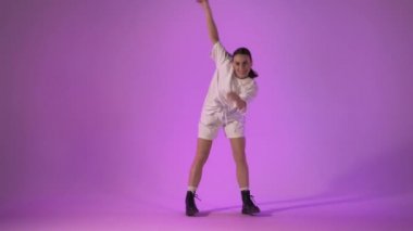 Menekşe arka planda hip hop dansı yapan genç bir kadın, stüdyo çekimi.