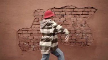 Genç bayan hip hop sokak dansı, arka planda kahverengi duvar, titrek pan shot