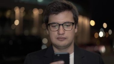 Gözlüklü iş adamı, arka planda telefonu kaydırıyor, kapat.