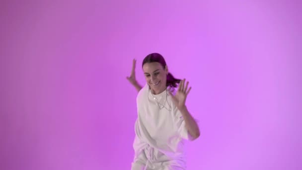 Young woman dancing hip hop on violet background, studio shot — Stock Video