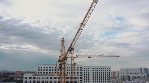 Construcción de grúas y casas de apartamentos sin terminar en construcción, tiro con dron — Vídeo de stock