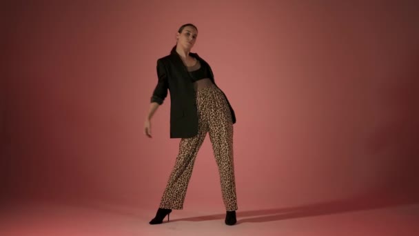 Wysokie obcasy taniec młodej kobiety w lampart spodnie, studio gimbal shot — Wideo stockowe