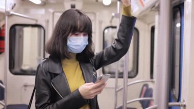 Metroda maskeli telefon kullanan genç bir kadın tırabzanda mercek fişeği tutuyordu.