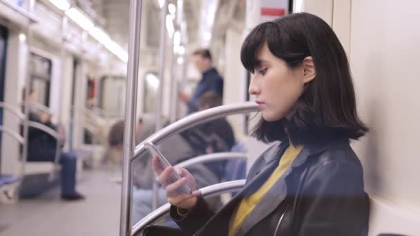 年轻女子使用电话特写，在地铁镜头内的座位上 — 图库视频影像