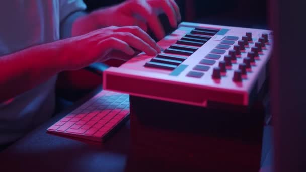 Manliga händer inspelning midi tangentbord i hemstudio, neon lampor — Stockvideo