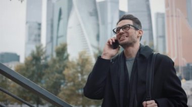 Paltolu bir adam telefonda konuşuyor sonbahar günü gökdelenlerin arka planında