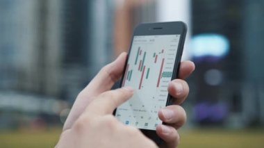 İşadamı borsa verilerini kontrol etmek için cep telefonu kullanıyor