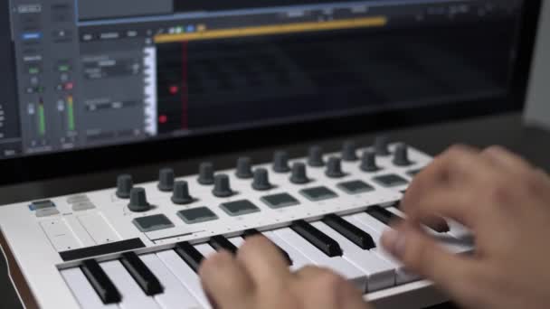 Чоловічі руки записують Midi-клавіатуру в секвенсорі в комп'ютері в домашній студії — стокове відео