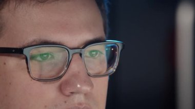 Gece geç saatlere kadar çalışıp bilgisayarın ekranına bakan bir adam.